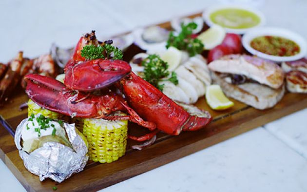 A selection of fresh Eden seafood and other produce on a wooden platter