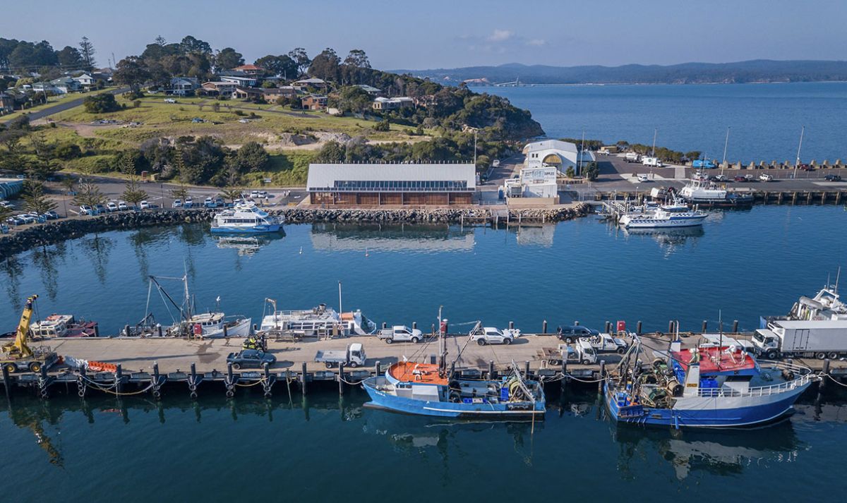 An aerial view of Eden Harbour with fishing boats moored at the wharves